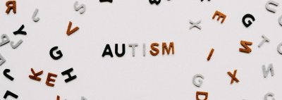 Letters scattered on a white background with the word "autism" spelled out in the center