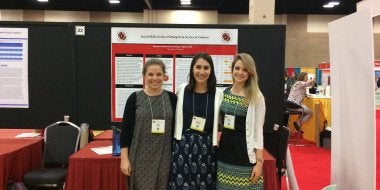 Three doctoral students at a research conference