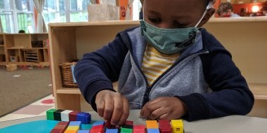 Child playing with unifix cubes