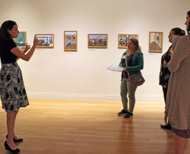 Woman standing in front of students in a museum 